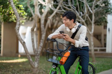 Bir bisikletçi en iyi güzergahı bulmak için akıllı telefon kullanırken, çevre dostu seyahat seçeneklerini kucaklayarak gezintiden zevk alır..