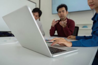 Dizüstü bilgisayarda UX stratejilerini gözden geçiren takım üyeleriyle yapılan odaklı bir toplantı tasarım iyileştirmeleri hakkında anlamlı tartışmalara yol açtı..