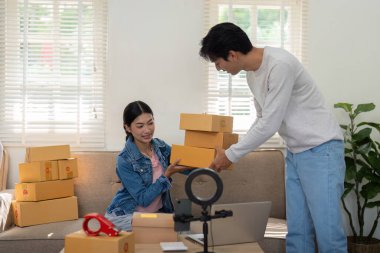 İş arkadaşı toplanmaya yardım ederken hevesli bir girişimci de envanterini kontrol ediyor. Görüntü, rahat bir çalışma alanında takım çalışmasını ve modern girişimciliği somutlaştırır..