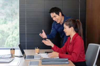 Modern bir ofiste, iki profesyonel mali verileri analiz ederken, iş büyümesi stratejileri üzerinde kafa yoruyor.