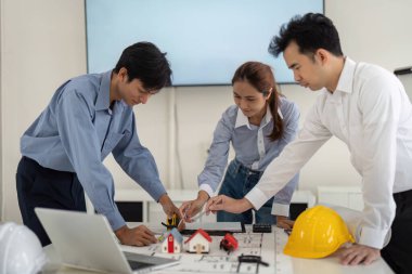 Meslektaşlar model evler için tasarımlar üzerinde işbirliği yaparken takım çalışmasını vurgulayan bir oturum ve pratik uygulamaları tartışır.