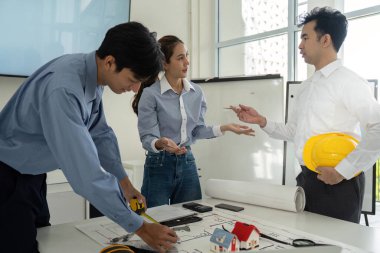 İnşaat sektöründeki profesyoneller, mimari planları incelerken, işbirliği çabaları ve tasarım çözümlerini ön plana çıkarırken bir tartışmaya giriştiler..