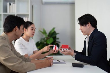 Çift, emlakçılarıyla farklı mülkleri değerlendiriyor ve hayallerindeki evi bulma özelliklerini ve tercihlerini aktif olarak tartışıyor..