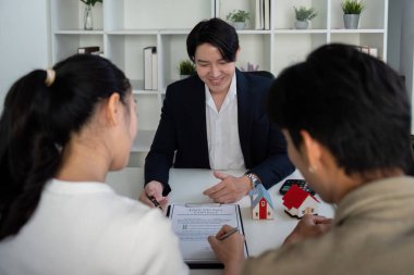 Gösterişli bir ofis ortamında, potansiyel emlak alımları, süreç süresince sözleşmelerin ve modellerin incelenmesi hakkında emlakçılarına birkaç danışmanlık yapılır..