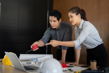 Bir mühendis, proje değerlendirmesi ve yürütülmesinde kritik bir adım olan tasarım fikirlerini bir meslektaşıyla tartışırken bir ölçüm aracı kullanır..