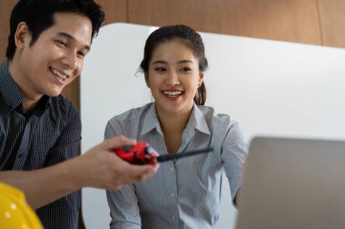 İki mühendis arasındaki dostça bir değiş tokuş takım çalışmasının önemini vurguluyor. Teknoloji kullanımları modern mühendislik uygulamalarını proje koordinasyonunda gösteriyor.