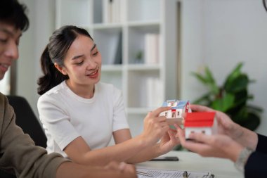 Çiftler emlakçılarıyla yakınlaşırken, çeşitli konut modellerini göstererek, gelecekteki evleri için mimari özellikler ve tercihler üzerinde tartışırlar..