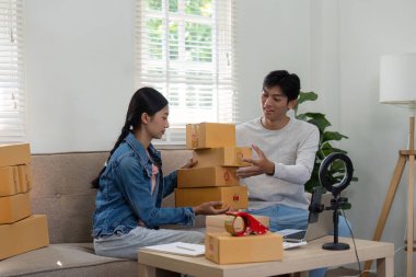 Ev düzenlemeleri sırasında, çift ürünlerini canlı bir oturum için düzenliyor, profesyonelliği rahat bir atmosferle harmanlıyor, girişimci ruhlarını gösteriyor.