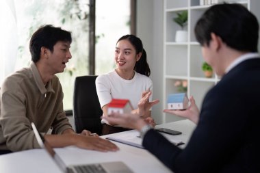 Kişisel tercihlerini birleştirirken, çift emlakçılarıyla ilişki kuruyor, mevcut konut seçeneklerini incelerken ev modellerini inceliyor.