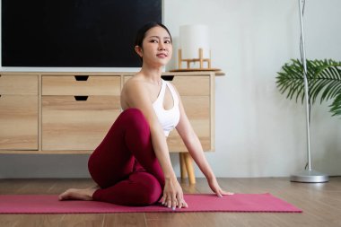 Yoga yapan bir kadın kararlılığını ve odaklanmasını belli eder. Bu egzersiz hareket kabiliyetinin artmasına yardımcı olur ve sırta ve omurgaya ferahlatıcı bir gerilme sağlar.