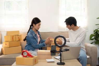 İkili, paketlenmiş ürünlerini sıralıyor, çevrimiçi müşterilerine en iyi nasıl sunulacağı konusunda beyin fırtınası yapıyor, girişimci ruhun özünü yakalıyor..