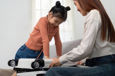 Resim, küçük bir kızın toplanmaya hevesle katıldığını gösteriyor. Yolculuk hazırlıklarını özel kılan heyecan ve bağlanma anlarına bir göz atıyor..