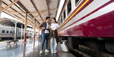 Çift, tren istasyonunda yan yana durur. Trenlerinin gelişini beklerken gülüyor ve bir anlık bağlantının keyfini çıkarırlar. Macera dolu bir ruh gösterirler..