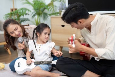 Anne babaların kızlarını müzik çalarken destekledikleri neşeli ve zengin bir ortam yarattıkları o an..