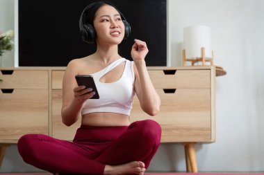 Bir yogi egzersiz sırasında kulaklıklarıyla müzik dinler, deneyimini geliştirir ve onu motive eder ve odaklar..