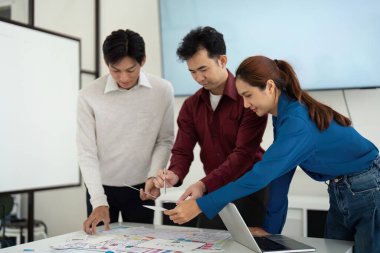 Üç UX UI tasarımcısı, kullanıcı deneyimi ve arayüz tasarımlarını geliştirmek için fikirlerini ve planlarını geliştirerek işbirlikçi bir tartışmaya girişir..