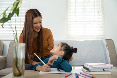 Bir anne, ev ödevi sırasında kızıyla yakınlaşır. Gülümseyip öğrenirken onları besleyen bir atmosfer yaratır..