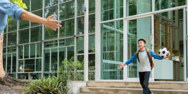 Bir çocuk, okuldaki bir günün ardından futbol antrenmanından heyecan getirerek hevesle annesine yaklaşır..