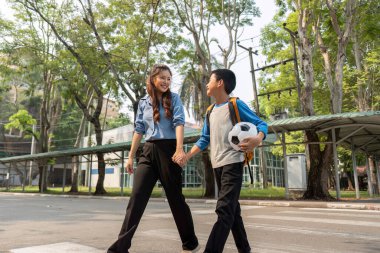 Öğrenci, uzun bir günün ardından sporun neşesini vurgulayarak ve okula dönerek sohbete dalarken rahatlıyor..