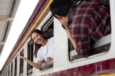 Bir çift tren yolculuğunun keyfini çıkarırken, bir tanesi neşe içinde pencereden el sallıyor, diğeri ise bu anın tadını çıkarıyor, neşeli maceralarının altını çiziyor..