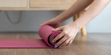 Yoga seansını tamamladıktan sonra, kendini işine adamış bir yogi paspasını kıvırarak, en iyi sağlık için temiz bir ortamın değerini vurguluyor..