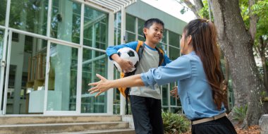 Okuldan hemen sonra bir anne ve oğul arasında samimi bir kucaklaşma, bağlarını ve futbolun neşesini kutluyorlar..