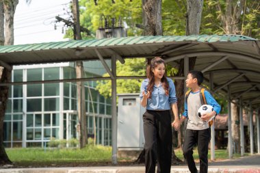 İkili, birlikte eve dönüş yolunda yol alırken keyifli bir değişimi paylaşıyor, futbol gibi akademik ve spor üzerine bir bağ kuruyor..