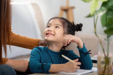 Evde okuyan bir kızın parlak bir sahnesi, yanında bakıcısıyla öğrenmeye hevesli, eğitici bir ortam sunuyor..