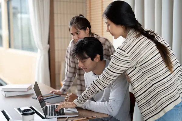 Canlı bir öğrenme ortamında, öğrenciler konu hakkındaki anlayışlarını geliştirmek için dizüstü bilgisayarın etrafında toplanır, araştırma ve tartışmalara girerler..