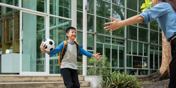 Heyecanlı bir okul gününden sonra, bir çocuk sevinçle annesine koşar, o da onu kollarını açarak karşılar. Bu an, aile sevincinin ve bağın özünü yakalar..