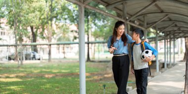 Bir anne ve oğlu okul ve futbol hakkında düşüncelerini paylaşıyorlar. Bu an, onların yakın ilişkilerini ve aile hayatındaki iletişimin önemini vurguluyor..