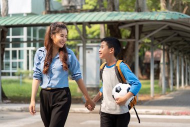 Bu dokunaklı sahne, bir anne ve oğulun okula yürürken canlı bir şekilde konuştuklarını, havada futbol hayalleri kurduklarını gösteriyor..