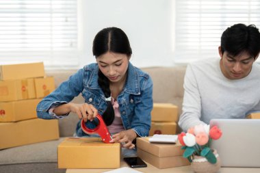 E- ticaret işlerine odaklanan bu çift, ev ofislerinden ürün nakliyesi ve organize etmek için birlikte çalıştıklarında etkinliklerini gösteriyor..