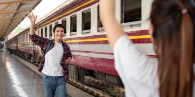 Tren istasyonunda eşine el sallayan bir adam, yolculuklarına başlarken heyecan ve duyguyu somutlaştırır..