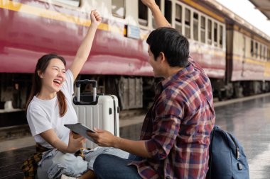 Yaklaşan yolculuklarından heyecan duyan genç bir çift, tren istasyonunda keyifli anlarını paylaşıyor. Seyahat ve birbirlerine olan sevgilerini ifade ediyorlar..
