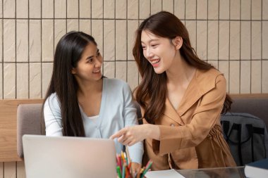 İki arkadaş laptopları üzerinde çalışırken, ilham verici bir çalışma ortamında fikir ve çözümleri paylaşarak canlı bir tartışmaya girişirler..