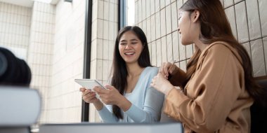 İki arkadaş, çalışma süresince fikirlerini ve geri bildirimlerini paylaşırken, neşe, yaratıcılık ve takım çalışmasını ifade eden tabletler üzerinde canlı bir tartışmaya girişirler..