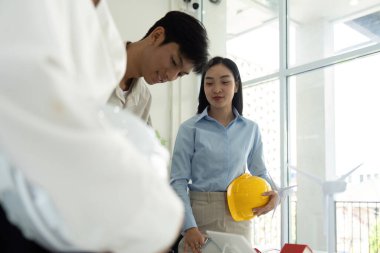 Takım çalışması ortamında yer alan profesyoneller, sürdürülebilir tasarım katmanlarını keşfederek, bunun gelecekteki projeler üzerindeki etkisini tartıyorlar..