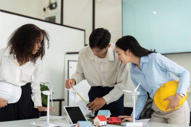 Çevre dostu mühendislik stratejileri geliştirmeye, sürdürülebilir proje tartışmalarında yenilikçi araç ve fikirlerden yararlanmaya odaklanan üç profesyonel.