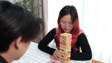 Gülen çift oturma odalarında ahşap oyunlar oynayarak eğleniyor. Sevgi kavramı, rahatlama ve evdeki eğlenceli anlarda bağlanma..