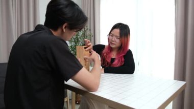 Gülen çift oturma odalarında ahşap oyunlar oynayarak eğleniyor. Sevgi kavramı, rahatlama ve evdeki eğlenceli anlarda bağlanma..