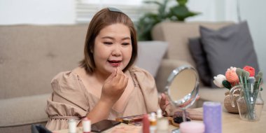 Dudaklarını parlak bir ruj gölgesiyle mükemmelleştiriyor. Güzellik rutininde detaylara dikkat çekiyor..