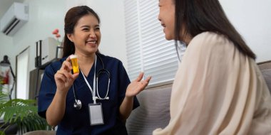 Ev ziyareti sırasında, bir hemşire yaşlı hastasıyla önemli ilaç bilgilerini paylaşarak bakım sırasında inşa edilen güveni vurgular..