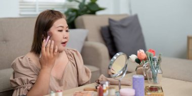 Görünüşüne odaklanarak, profesyonel fırçalarla allık sürüyor, güne hazırlanırken yanaklarını büyütüyor..