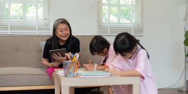 Şefkatli bir büyükanne torunlarına okul ödevlerinde yardım eder, öğrenme ortamını geliştirir. Bu sahnede aile desteğinin eğitimde önemi vurgulanıyor.