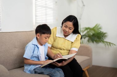 Kendini işine adamış bir anne, oğluna okul ödevlerinde yardımcı olur. Öğrenme ve akademik gelişmesini teşvik etme sevgisini arttırır..