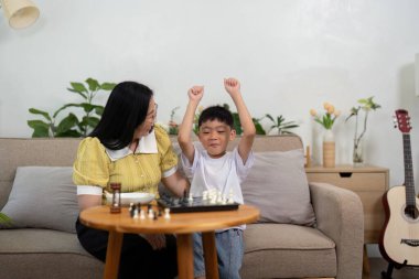 Bir evladın annesiyle satranç maçını kazanmasını ve aile hayatındaki mutluluğu ve tecrübelerini paylaşmasını kutlayan gururlu bir an..