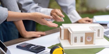 Mimarlardan oluşan bir ekip, yenilikçi tasarımlar ve modern inşaat için çevre dostu malzemelere odaklanan sürdürülebilir bir yapı modelini inceliyor..
