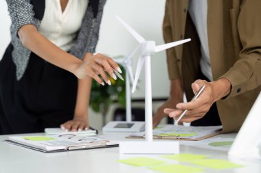 Profesyoneller, planlarında rüzgar türbini modellerini kullanırken ESG girişimleri için yenilikçi stratejiler geliştirmek için bir tasarım tartışmasına giriştiler..