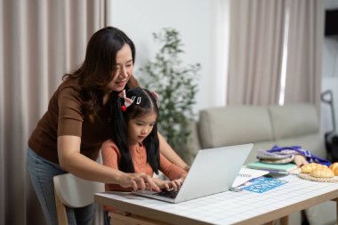 Bir anne kızına çevrimiçi okul ödevlerinde yardımcı olur ve yeni öğrenim yılına hazırlanırken destekleyici bir öğrenim ortamı sağlar..
